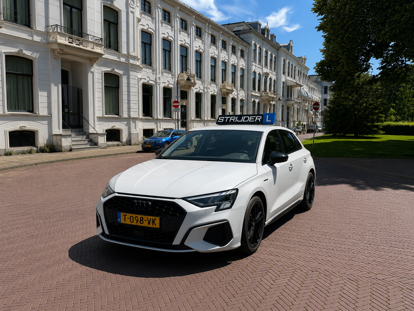Witte Audi A3 schakellesauto van Rijschool Strijder in een Haarlemse straat